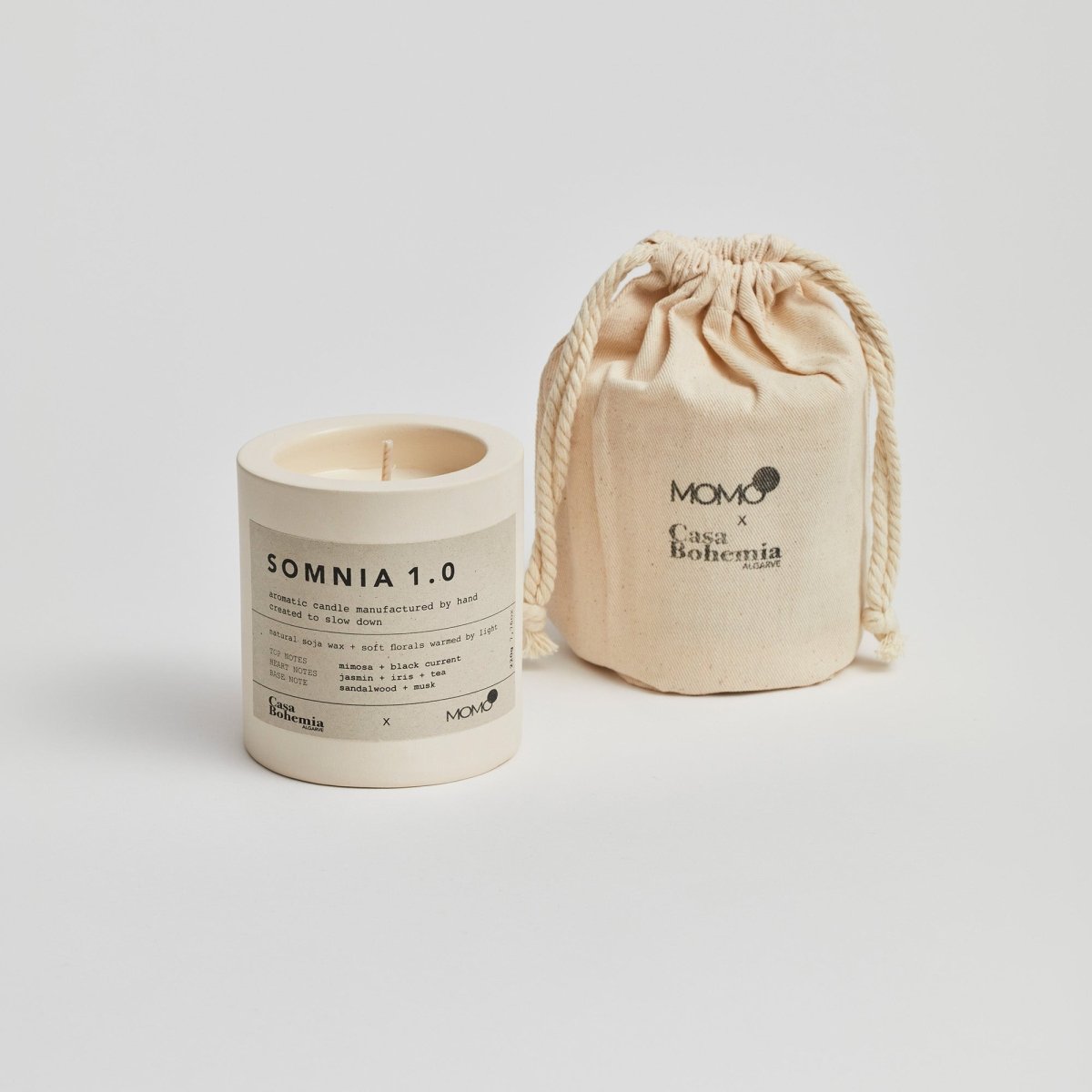 Somnia 1.0 aromatic candle with cream drawstring pouch by Momo and Casa Bohemia on white background