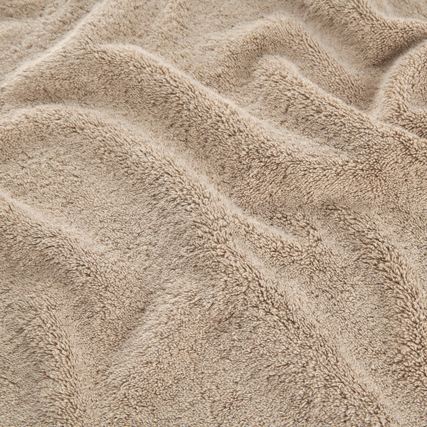 Set di asciugamani in bambù beige che mostra il dettaglio della texture morbida di asciugamani viso, mano e bagno