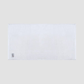 Tappetino da bagno bianco in bambù Momo Cotton – morbido, assorbente, asciugatura veloce e sostenibile.